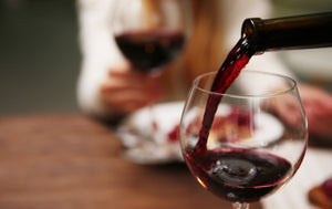 pouring red wine in glass